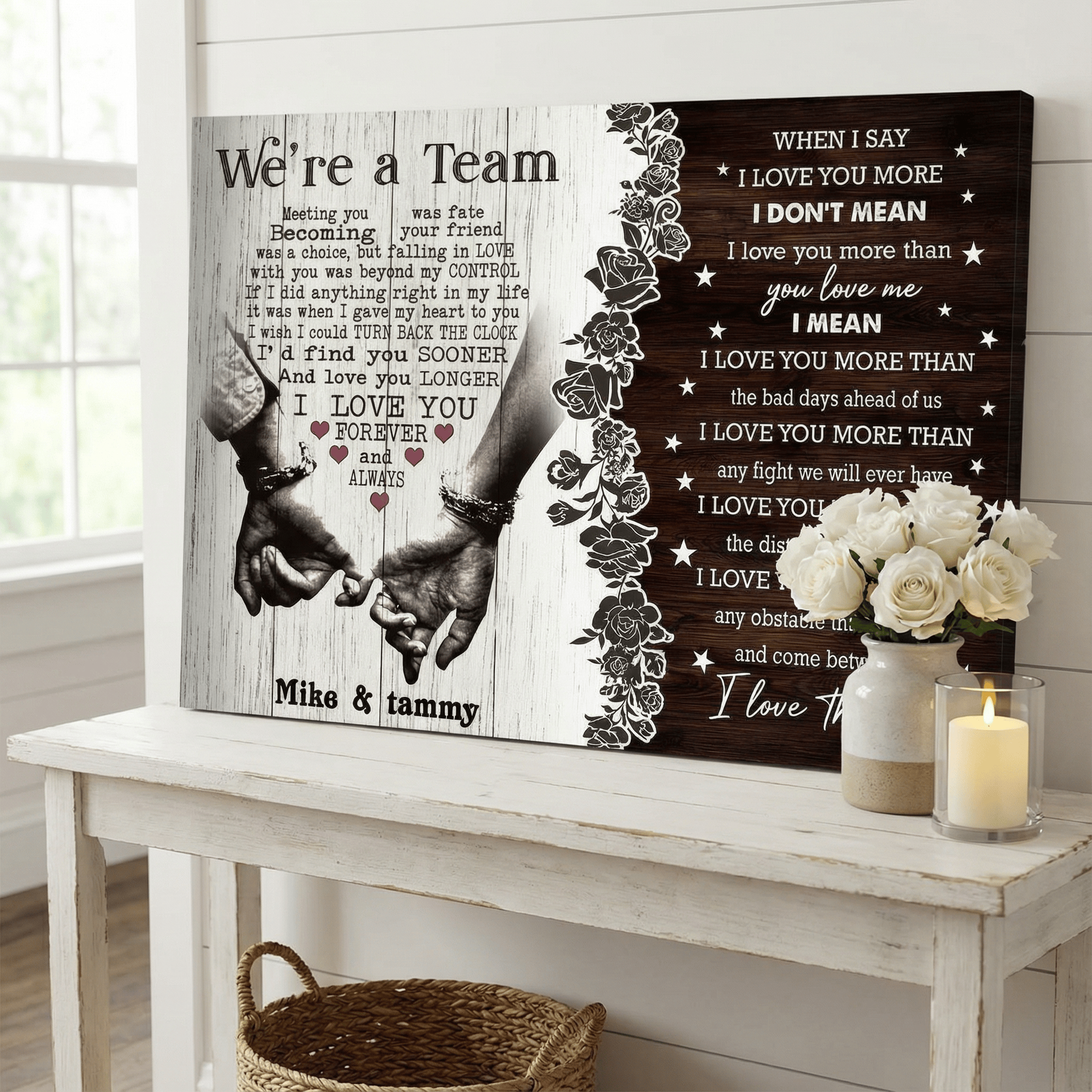 Two framed poems on a wooden table with flowers and a candle.