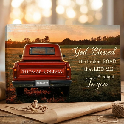 Canvas print with a red truck in a field at sunset, personalized text, and decorative elements on a wooden surface.