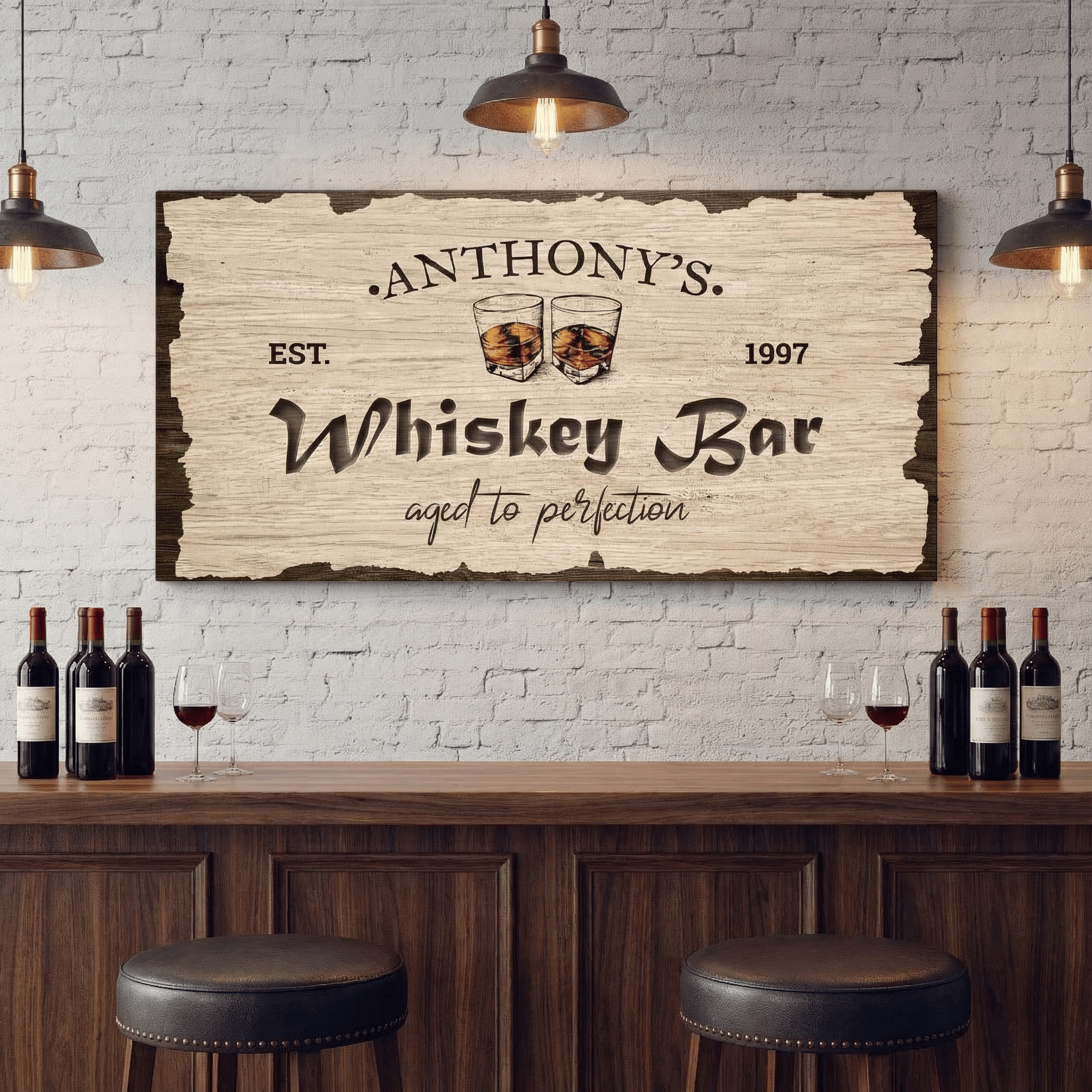 Wooden bar with 'Anthony's Whiskey Bar' sign, wine bottles, and glasses against a white brick wall.